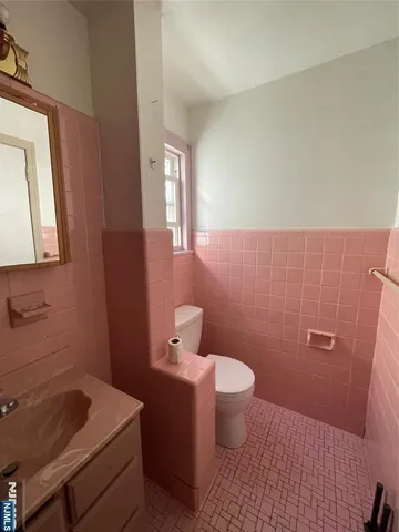 a bathroom with a sink and mirror with toilet