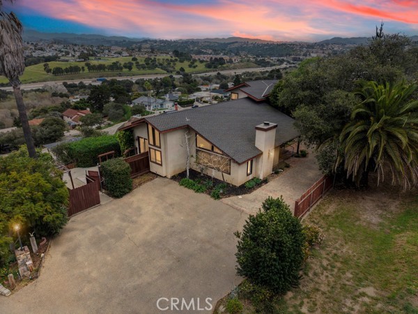 an aerial view of a house with a yard and mountain