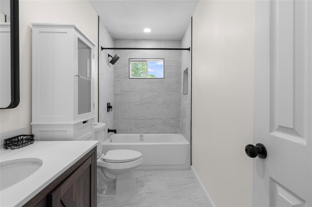 211 Southeast 7th Street Cooper, TX 75432 - Photo 17 of 29 a bathroom with a sink toilet a shower and a mirror