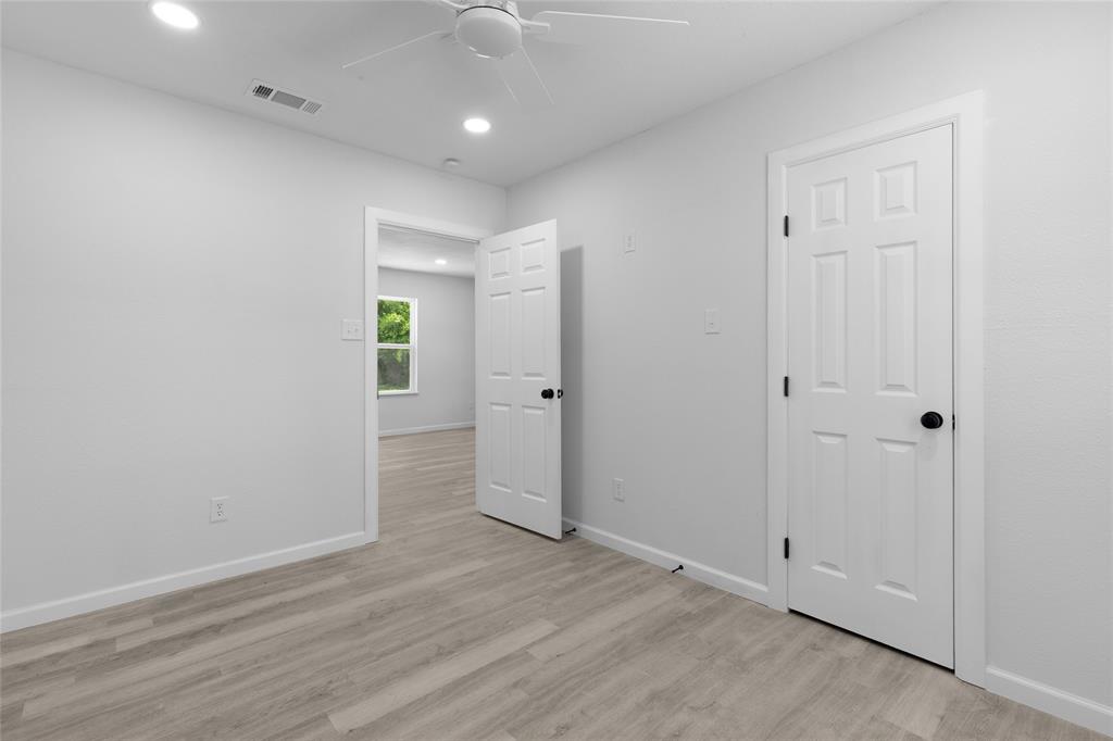 211 Southeast 7th Street Cooper, TX 75432 - Photo 18 of 29 an empty room with wooden floor and windows