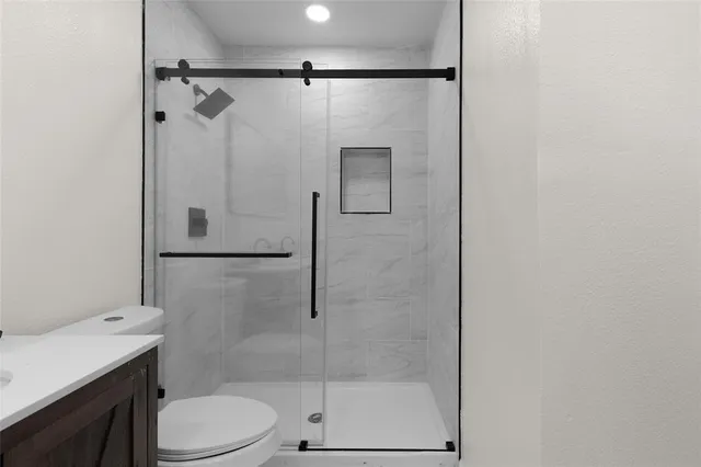 a bathroom with a shower a toilet and sink