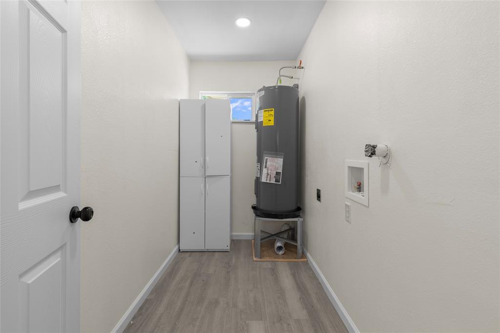 211 Southeast 7th Street Cooper, TX 75432 - Photo 23 of 29 a view of a hallway with wooden floor a sink and a mirror