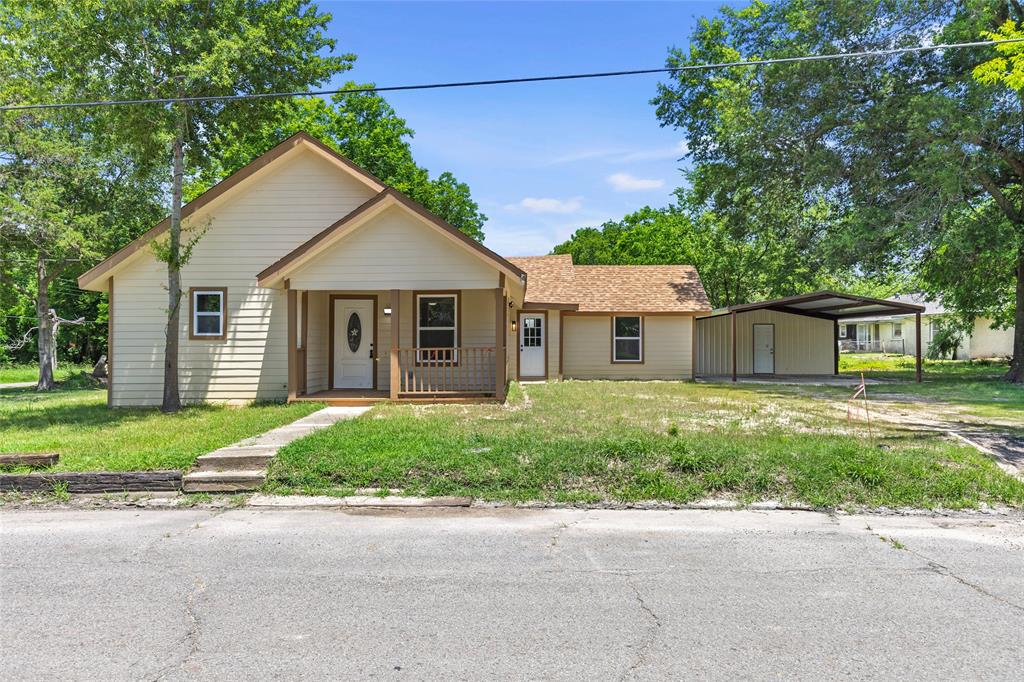 211 Southeast 7th Street Cooper, TX 75432 - Photo 4 of 29 a front view of a house with a garden and yard