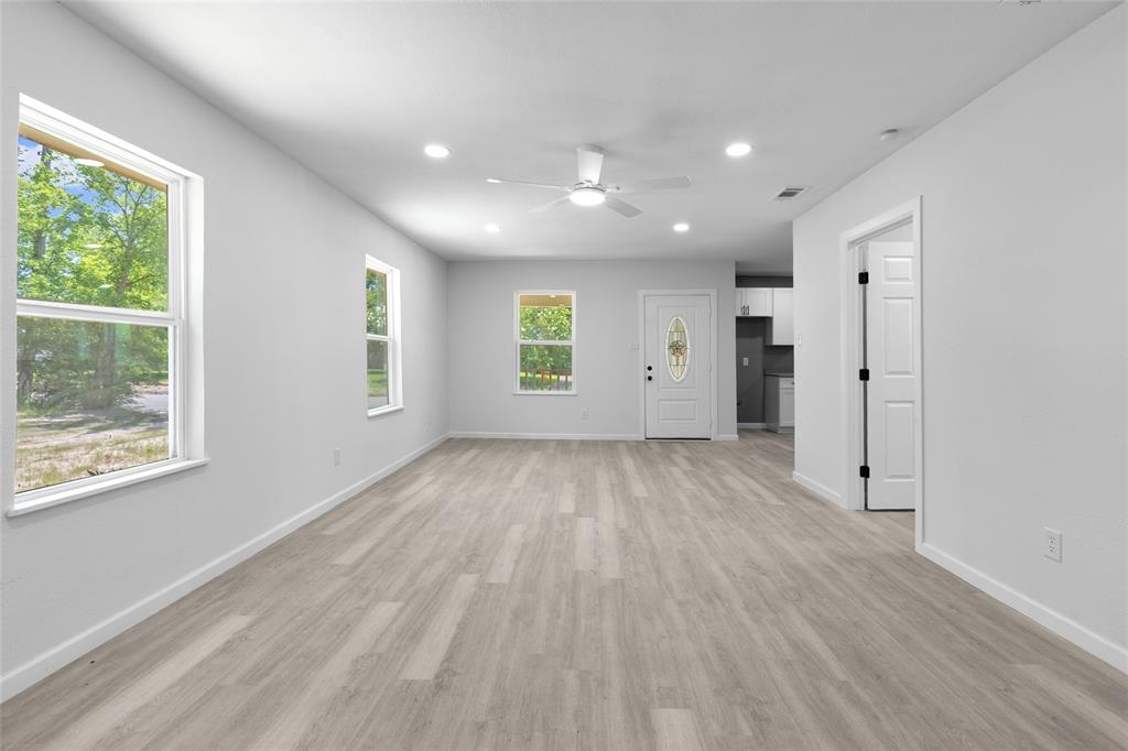 211 Southeast 7th Street Cooper, TX 75432 - Photo 6 of 29 an empty room with wooden floor and windows