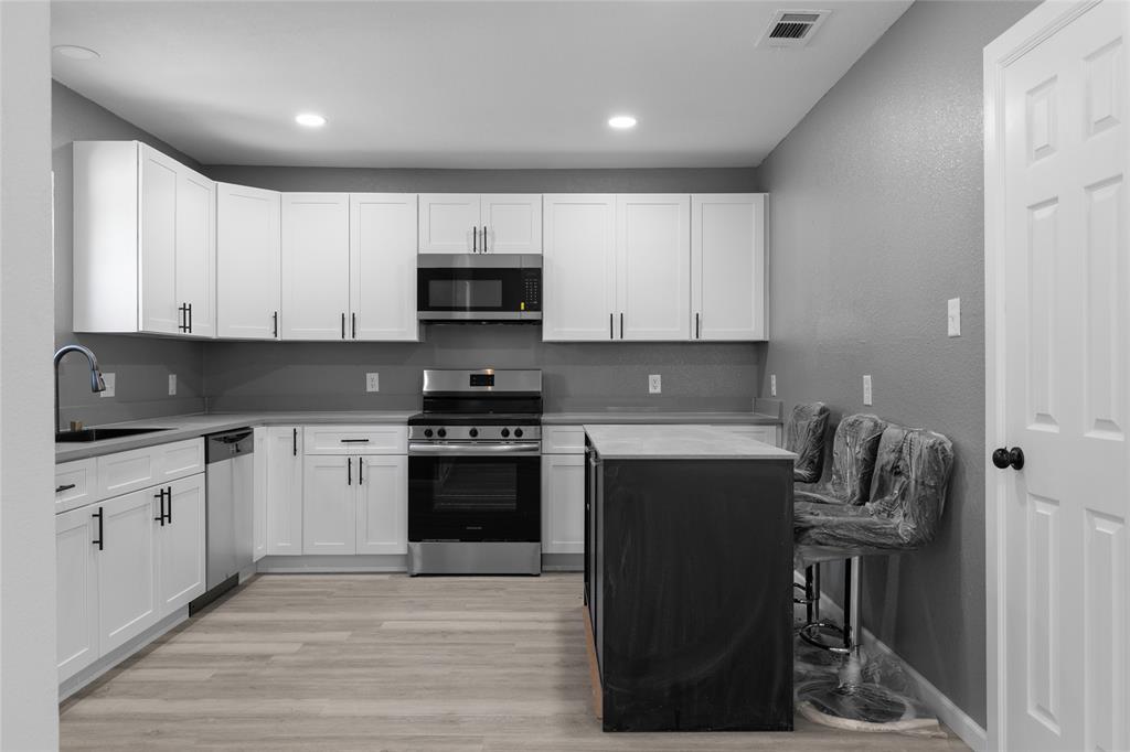 211 Southeast 7th Street Cooper, TX 75432 - Photo 7 of 29 a kitchen with a sink a stove and cabinets