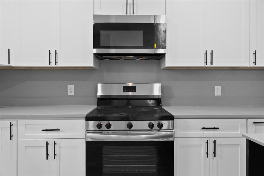 211 Southeast 7th Street Cooper, TX 75432 - Photo 10 of 29 a kitchen with stainless steel appliances granite countertop white cabinets and a stove
