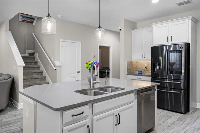 a kitchen with stainless steel appliances granite countertop a sink a refrigerator and a stove