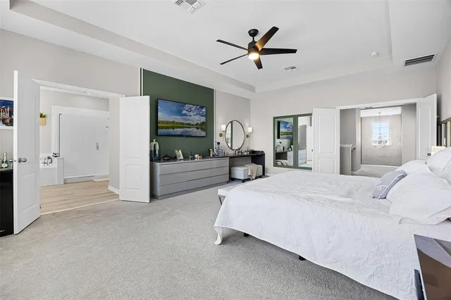 a spacious bedroom with a bed and a chandelier