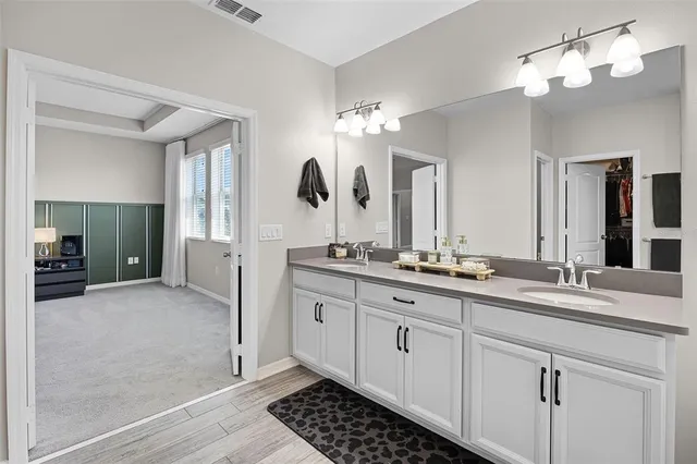 a spacious bathroom with a double vanity sink a mirror and a shower