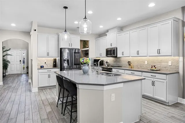 a kitchen with white cabinets stove and refrigerator