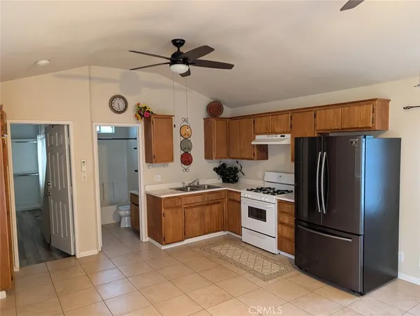 a kitchen with stainless steel appliances granite countertop a refrigerator a oven a sink with dishwasher and refrigerator