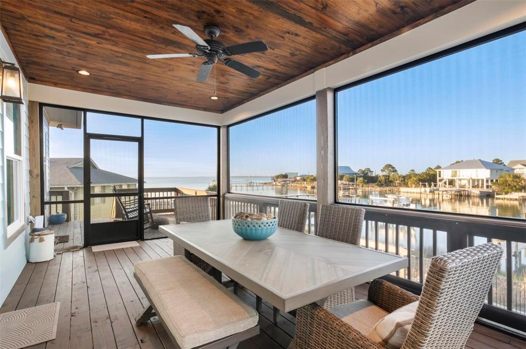 331 Land Street Eastpoint, FL 32328 - Photo 18 of 36 a view of a balcony dining table and chairs with wooden floor