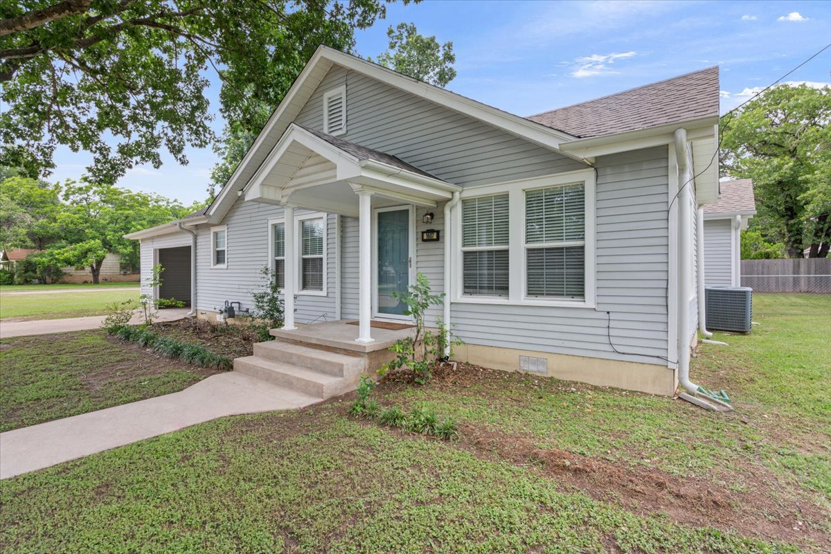 1607 North Harding Avenue Cameron, TX 76520 - Photo 5 of 37 A welcoming front porch with white columns graces this light-colored siding home.