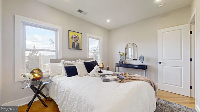 a living room with furniture kitchen view and a wooden floor