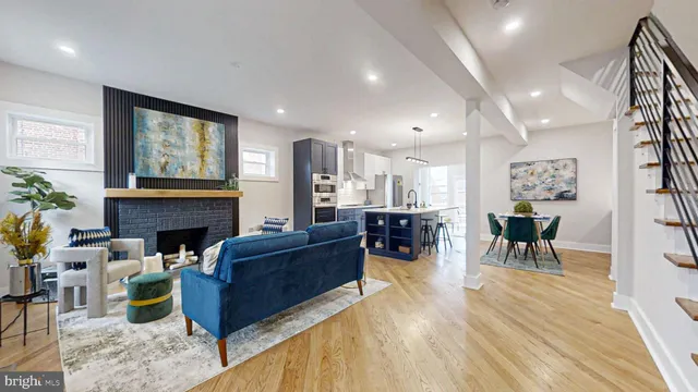 a living room with furniture kitchen view and a wooden floor