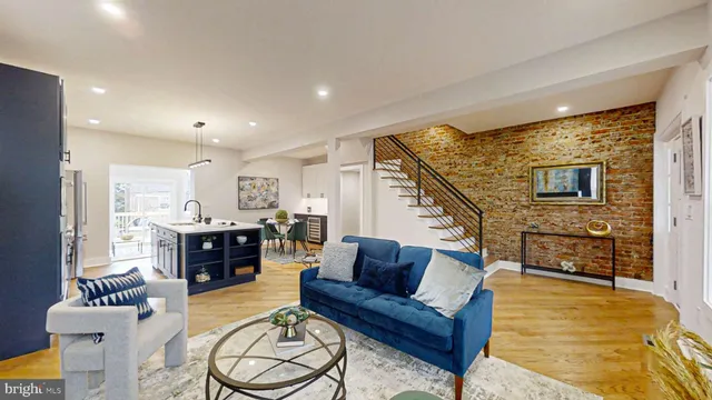 a kitchen with stainless steel appliances kitchen island granite countertop a refrigerator a stove a sink a dining table and chairs