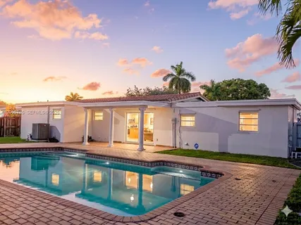 a view of a house with pool and chairs