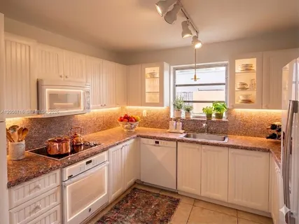 a kitchen with a sink cabinets and window