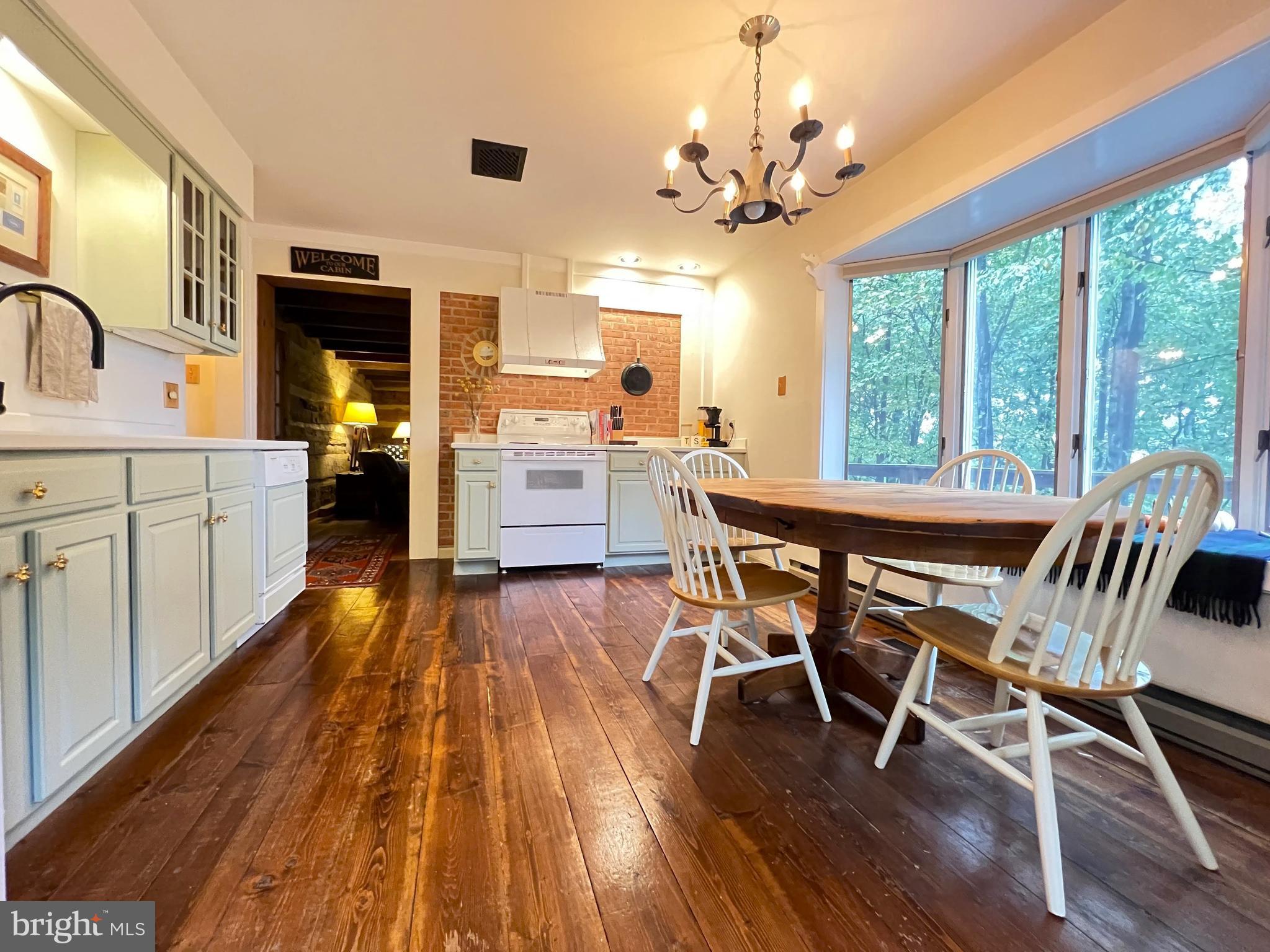 259 Riley Hollow Road Huntly, VA 22640 - Photo 12 of 33 a dining room with wooden floor a chandelier a wooden table and chairs