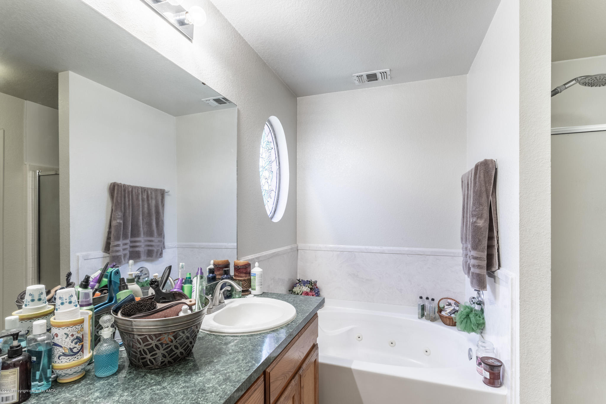 1111 Pikes Peak Drive Amarillo, TX 79110 - Photo 9 of 15 a bath room with a mirror and a bath tub