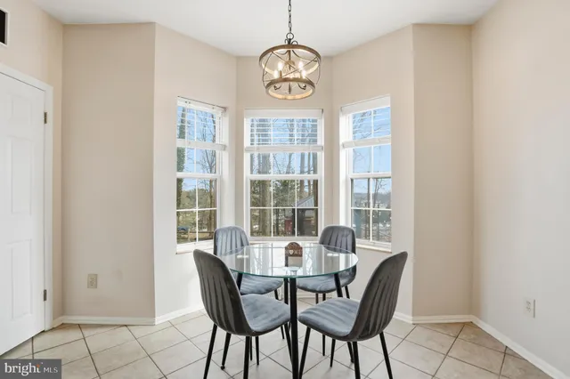a kitchen with a dining table chairs and white cabinets