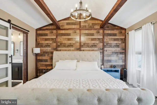 a bedroom with a large bed and a chandelier