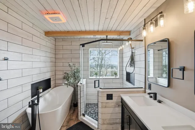a spacious bathroom with a granite countertop sink mirror and bathtub