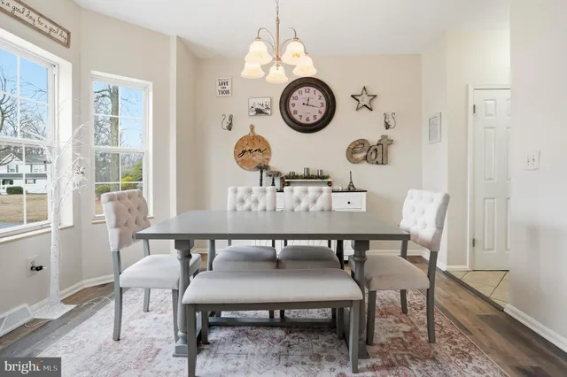 a view of a dining room with furniture clock and wooden floor