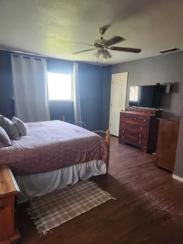 a spacious bedroom with a bed and a chandelier