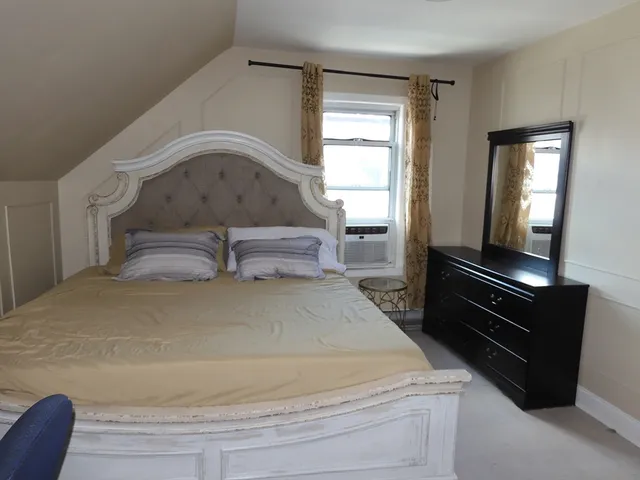 a bedroom with a bed and a large window