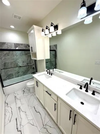 a bathroom with a double vanity sink mirror and shower