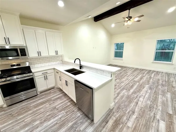 a kitchen with a sink stove and cabinets