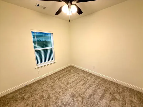 an empty room with a window and a ceiling fan