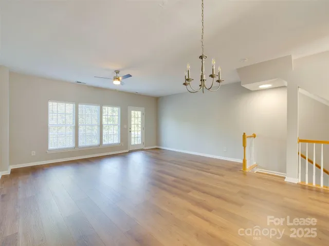 a view of a livingroom with wooden floor and a ceiling fan