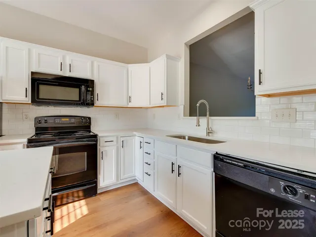 a view of hallway with window and wooden floor