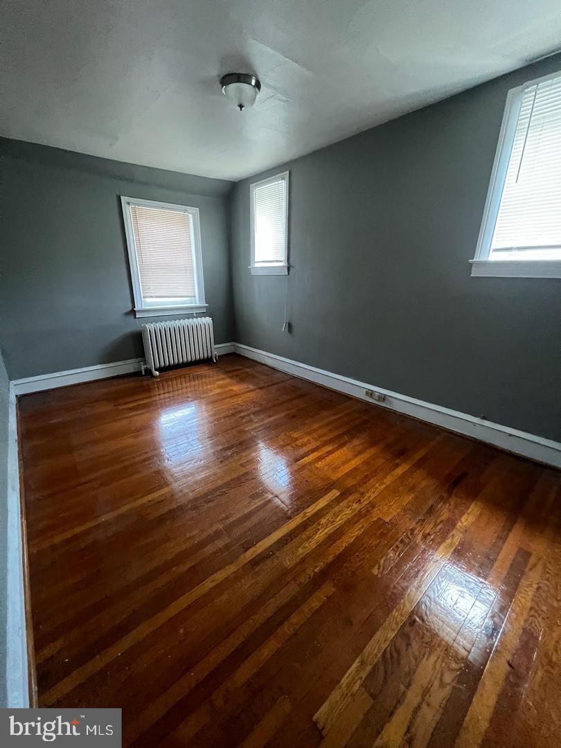 5010 Copley Road Philadelphia, PA 19144 - Photo 5 of 6 a view of an empty room with wooden floor and windows