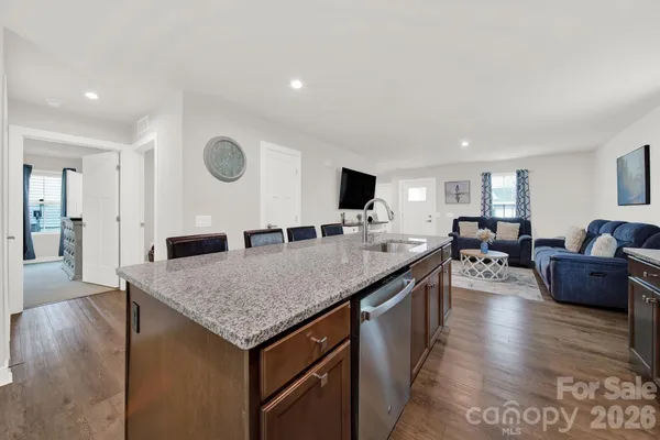 a view of living room with granite countertop couches with wooden floor