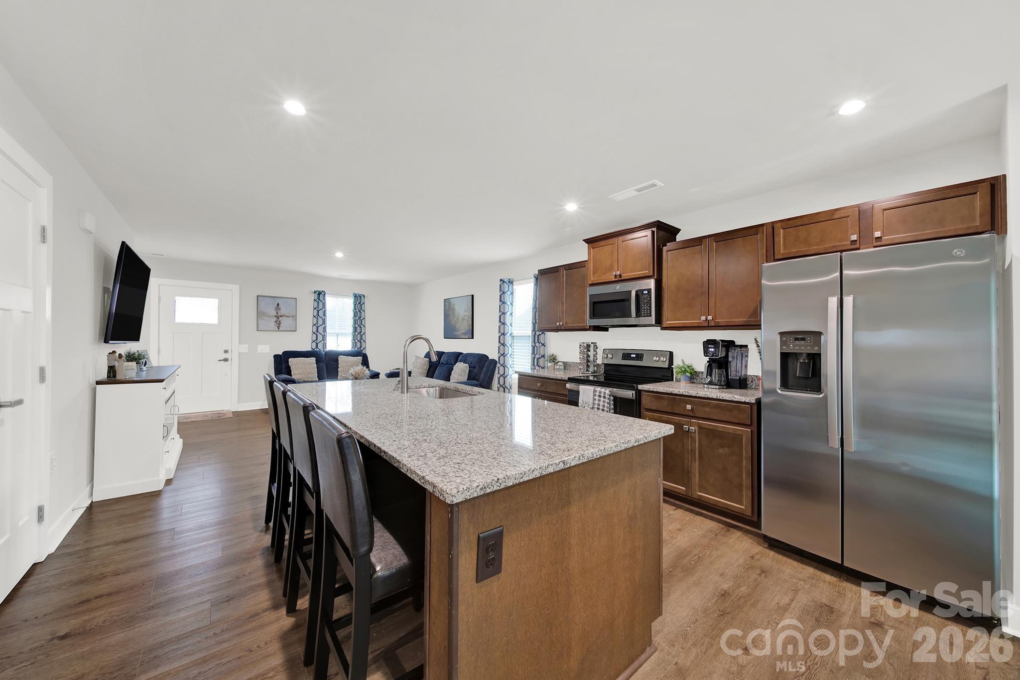 515 Grandiflora Avenue Lancaster, SC 29720 - Photo 9 of 29 a kitchen with stainless steel appliances granite countertop a refrigerator a stove a sink a dining table and chairs