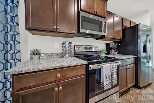 a kitchen with granite countertop a sink stove and microwave