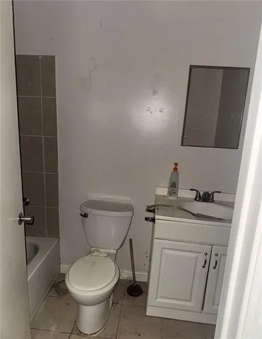 a bathroom with a granite countertop toilet a sink and a mirror