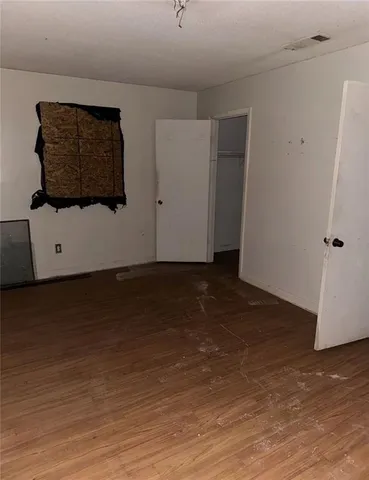 a view of an empty room with wooden floor and cabinet