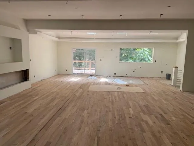 a view of a room with wooden floor and a window