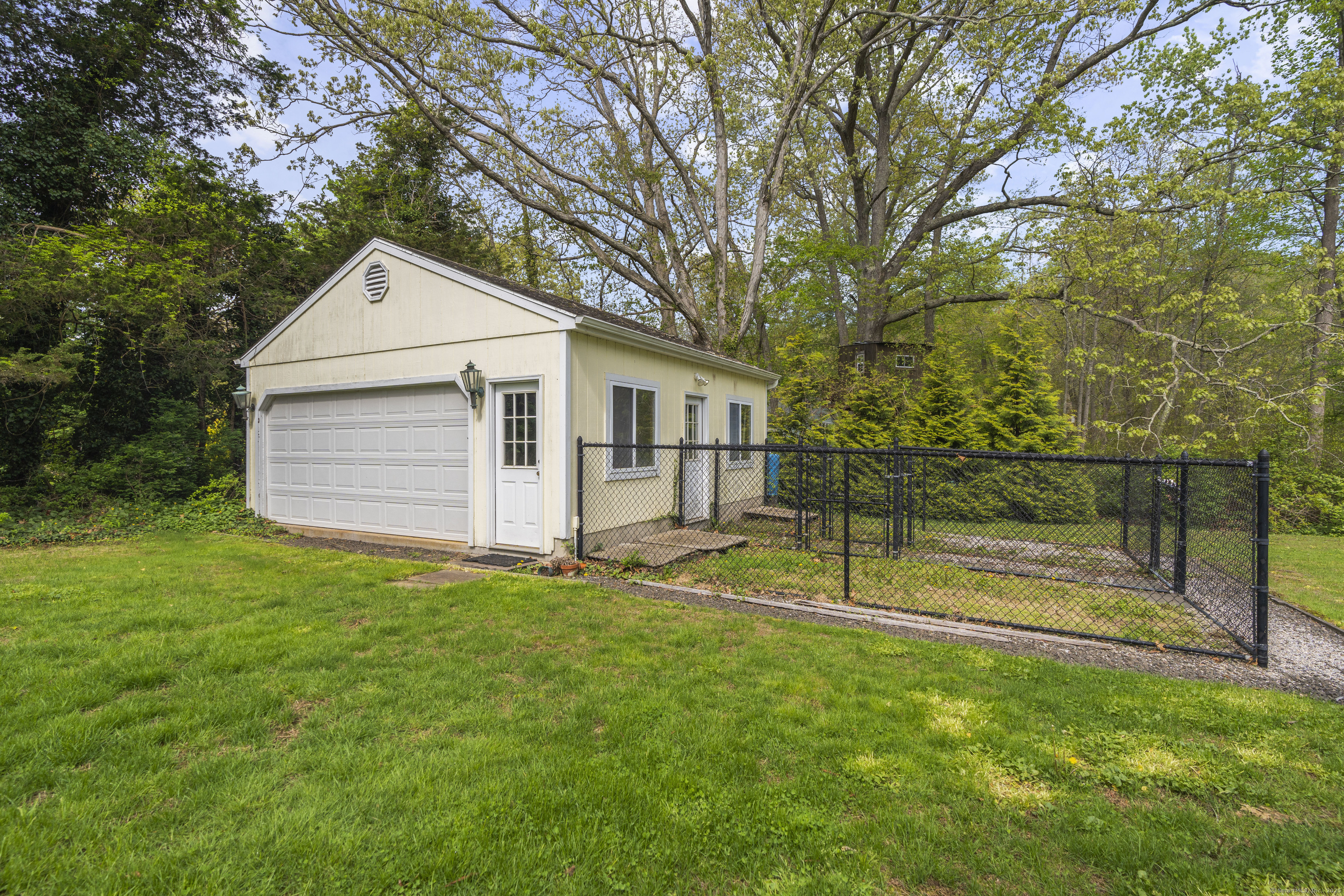 55 Harbor View Road Guilford, CT 06437 - Photo 29 of 38 a view of a backyard with wooden fence and a large tree