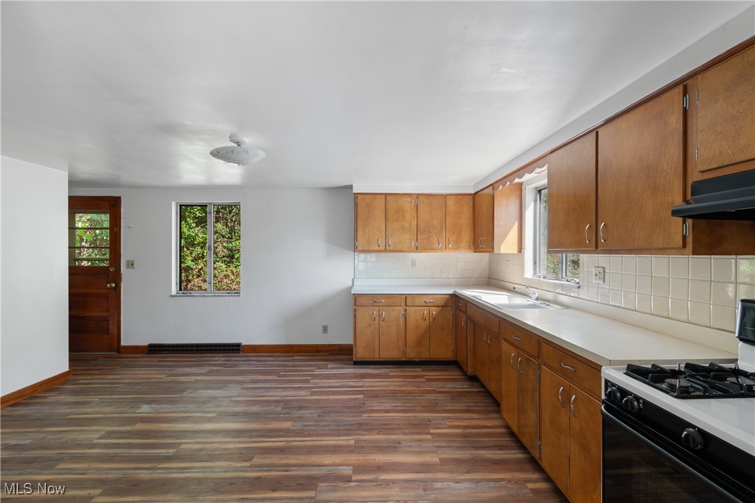 56321-56323 Riley Road Bridgeport, OH 43912 - Photo 28 of 40 Kitchen with tasteful backsplash, dark hardwood / wood-style flooring, white range with gas stovetop, and a wealth of natural light