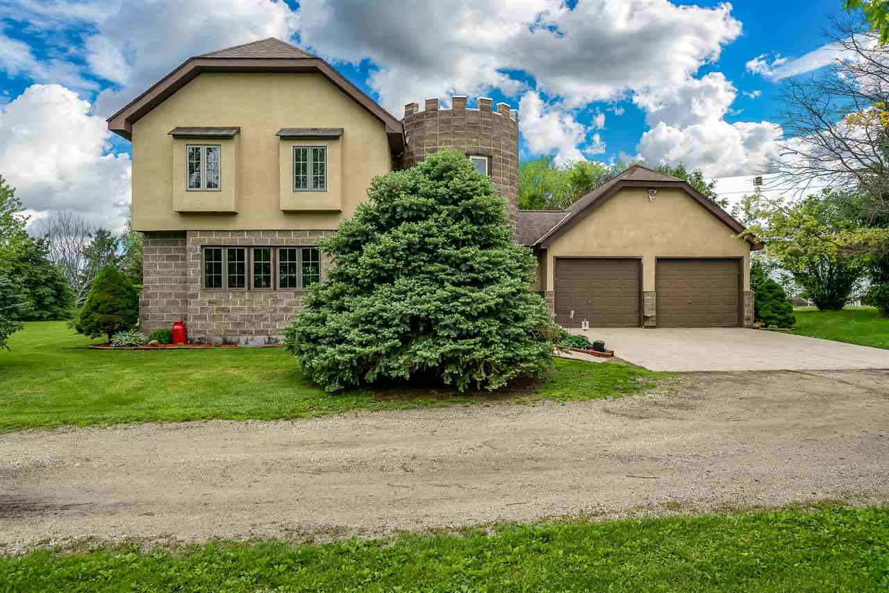 15666 East Bethel Road Rochelle, IL 61068 - Photo 1 of 22 a front view of a house with a garden and plants