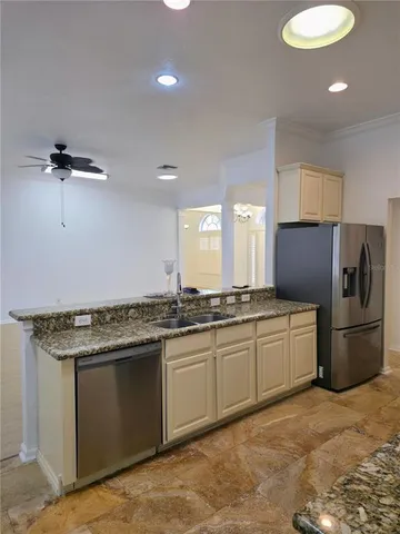 a kitchen with granite countertop a sink stainless steel appliances and cabinets