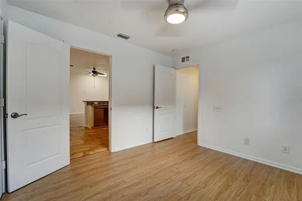 an empty room with wooden floor and a bathroom