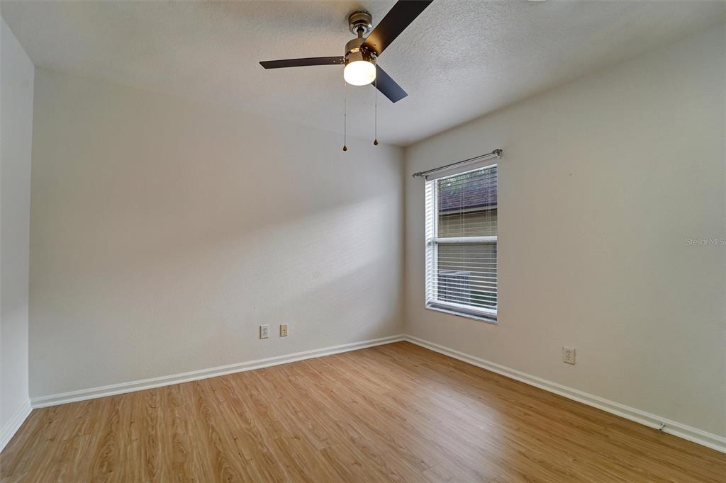 19111 Fern Meadow Loop Lutz, FL 33558 - Photo 24 of 41 an empty room with wooden floor chandelier fan and windows