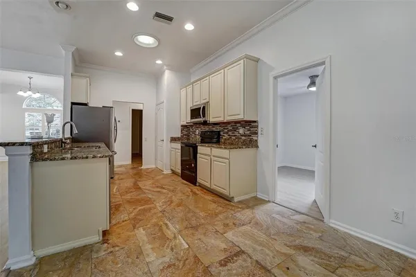 a kitchen with kitchen island granite countertop a stove a refrigerator and a sink