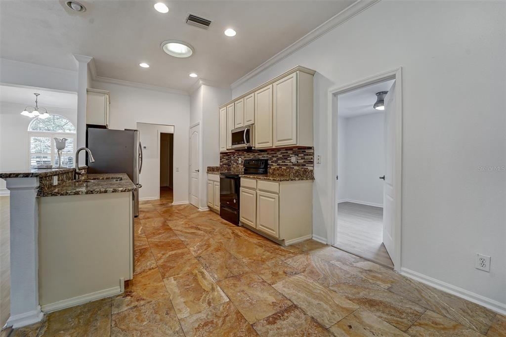 19111 Fern Meadow Loop Lutz, FL 33558 - Photo 29 of 41 a kitchen with kitchen island granite countertop a stove a refrigerator and a sink